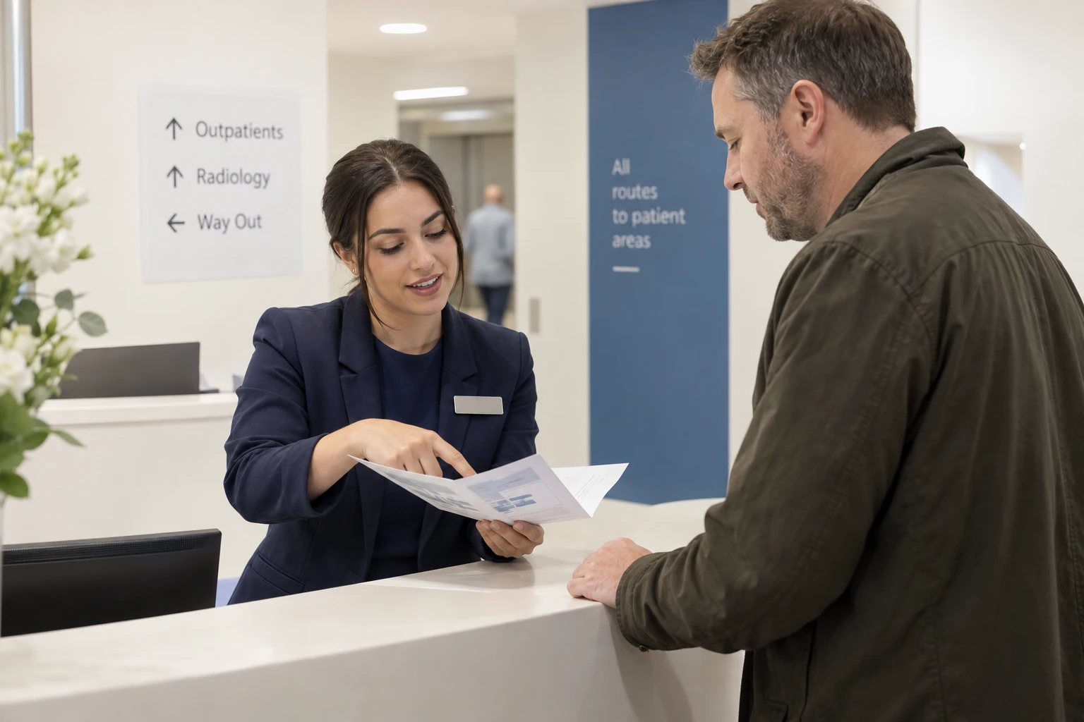 Penguin ePulse use case: Hospital information-desk staff helping a visitor understand service arrangements — illustrative editorial scene